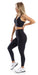 Full body side view of girl wearing black Midnight Eco Ultra High Waist Leggings and matching bra lifting right heel and putting left hand on waist