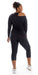 Full body rear view of girl wearing black Midnight Off The Shoulder Long Sleeve Tee and matching bottoms looking to her right and putting one leg forward